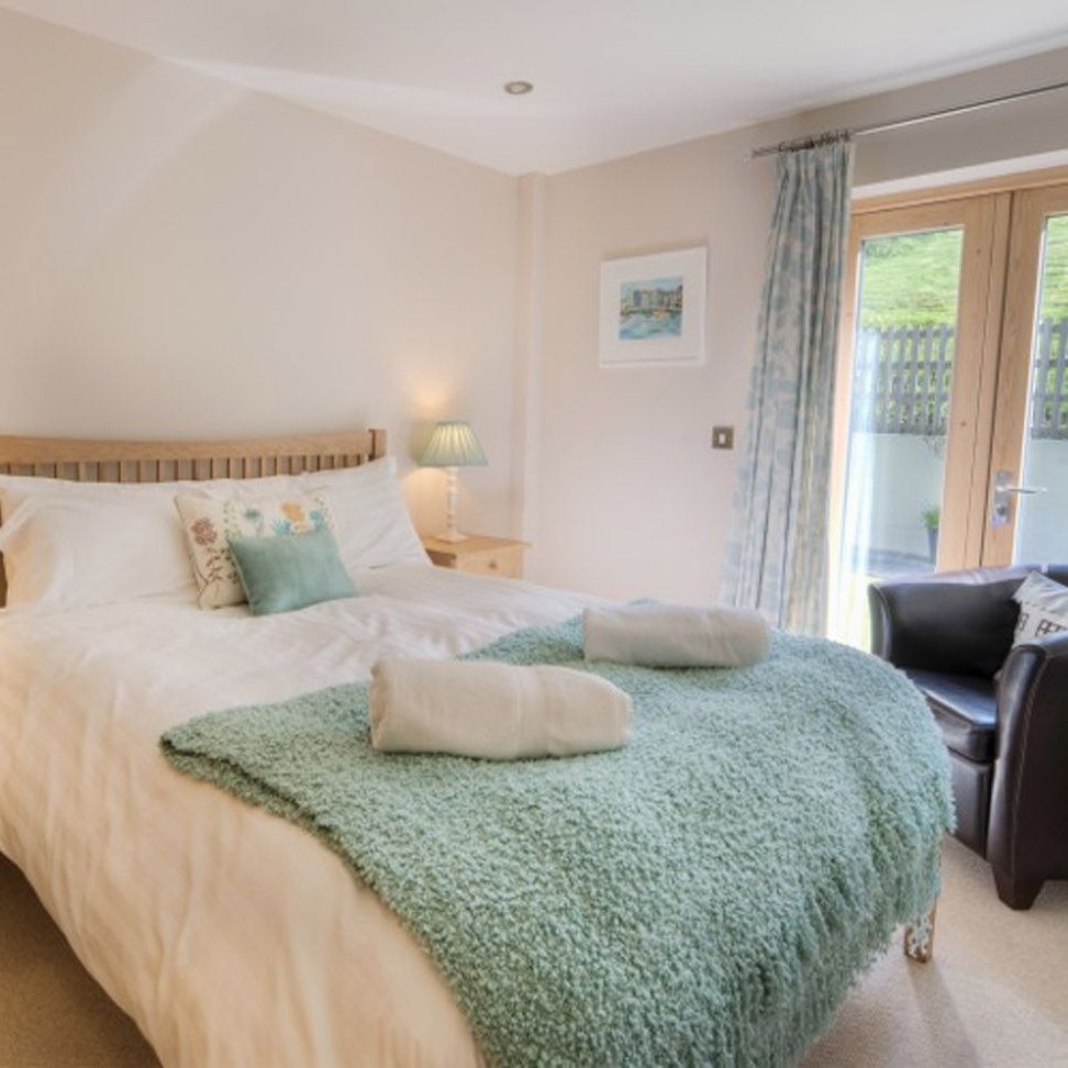 Cozy bedroom with a double bed, bedside tables, lamps, and patio doors