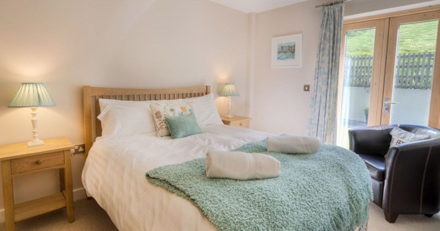 Cozy bedroom with a double bed, bedside tables, lamps, and patio doors