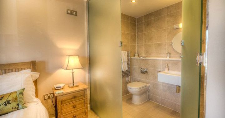 Bedroom with en-suite bathroom separated by frosted glass door