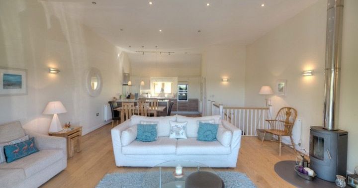 Modern living room with white sofa, fireplace, and dining area