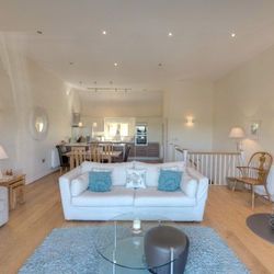Modern living room with white sofa, fireplace, and dining area