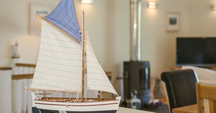 Model sailboat displayed indoors on a table