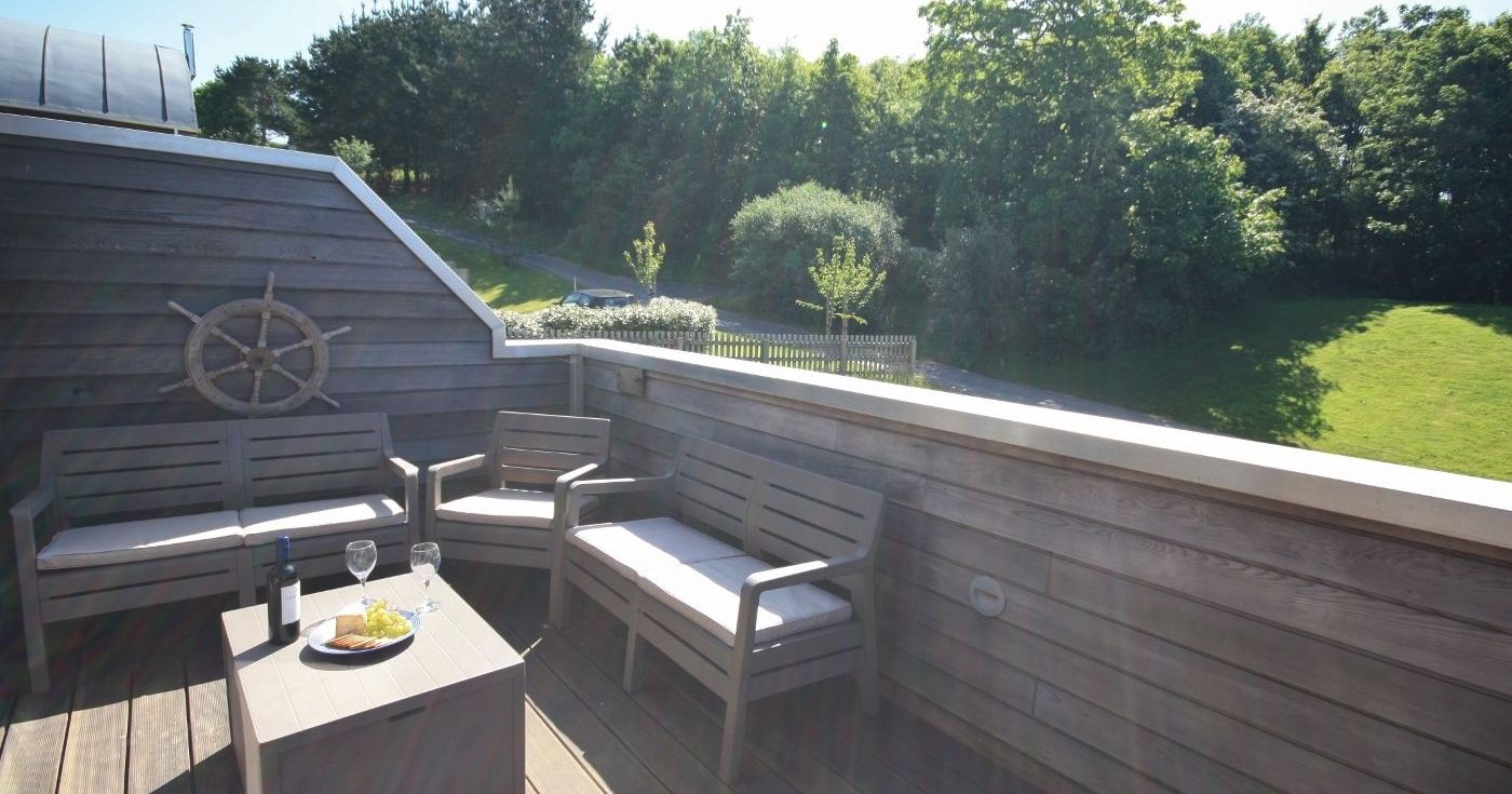 Outdoor wooden deck with patio furniture and garden view