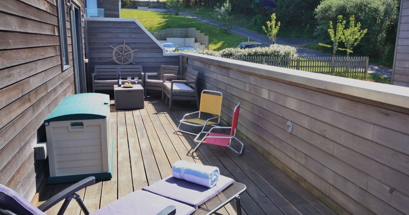 Wooden deck patio with lounge chairs, seating area, and outdoor furniture