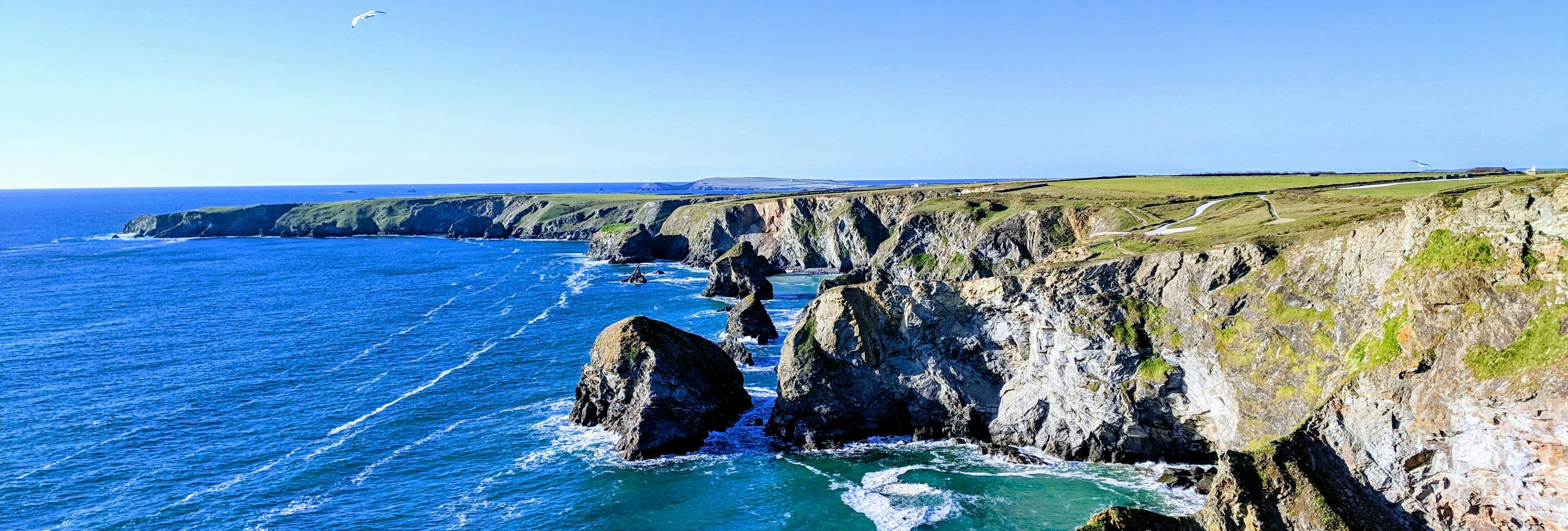 Rocky cliffs and blue ocean under a clear sky