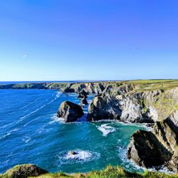Rocky cliffs and blue ocean under a clear sky