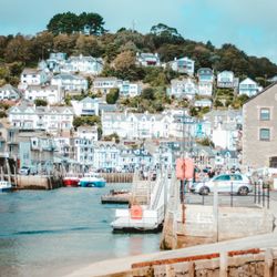 Quaint seaside town with hilltop houses and a small harbor with boats.