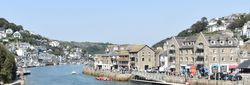 Coastal town with stone buildings and boats along the waterfront on a sunny day