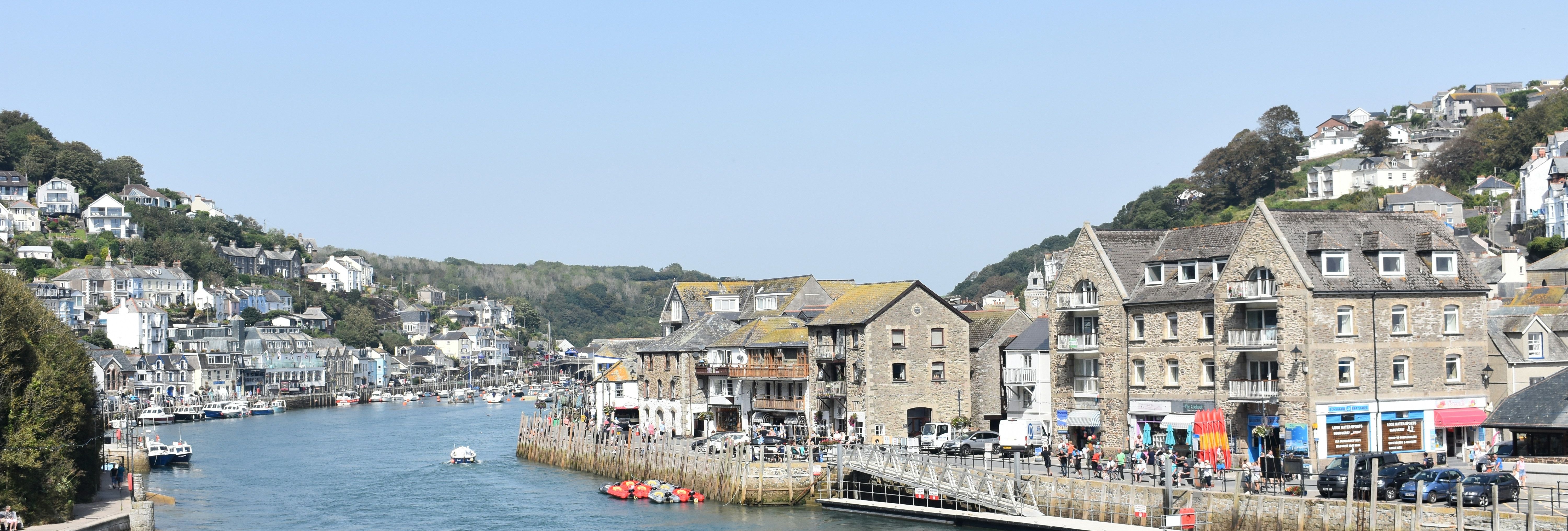 Coastal town with stone buildings and boats along the waterfront on a sunny day