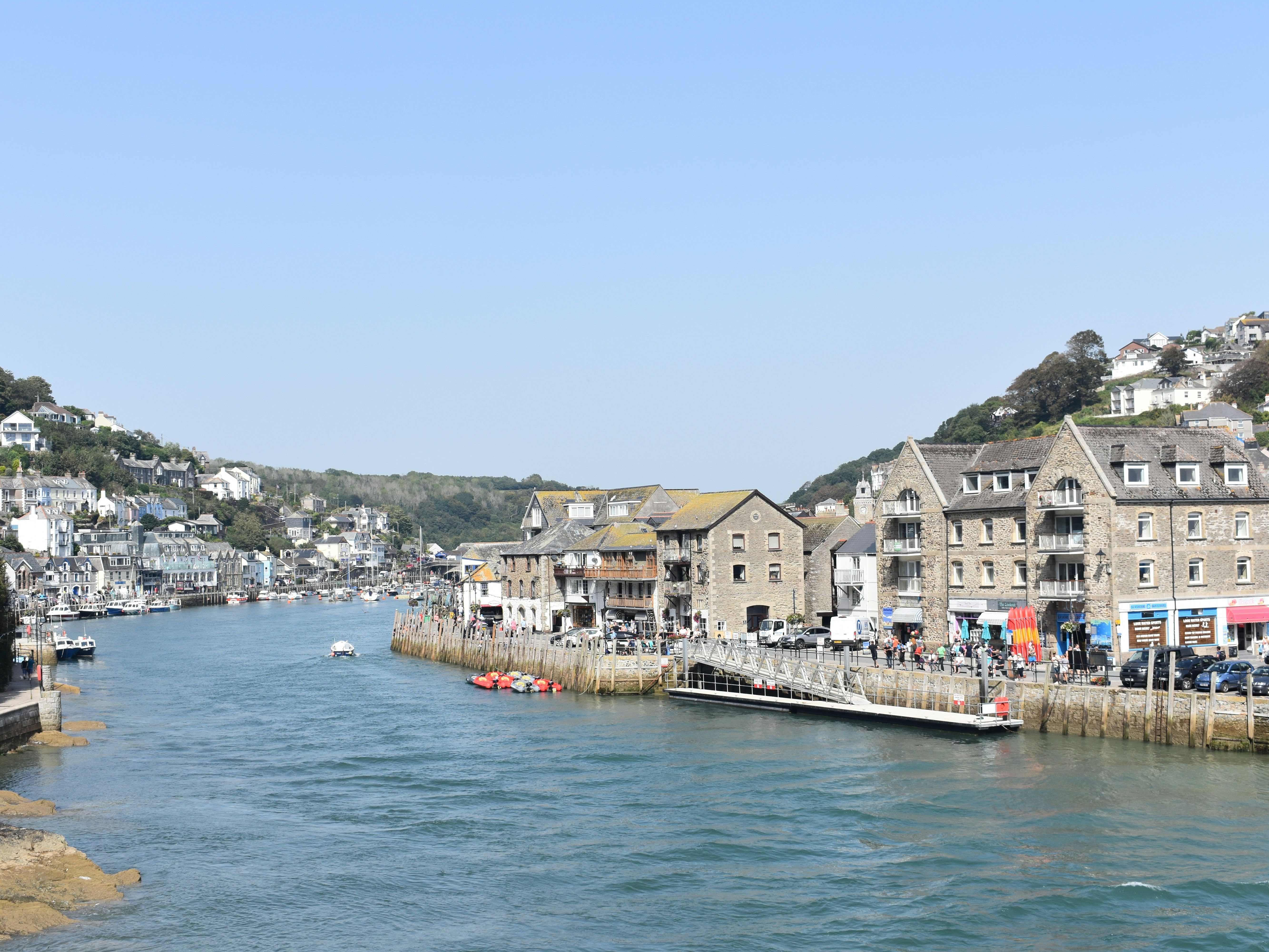 Coastal town with stone buildings and boats along the waterfront on a sunny day