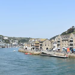 Coastal town with stone buildings and boats along the waterfront on a sunny day