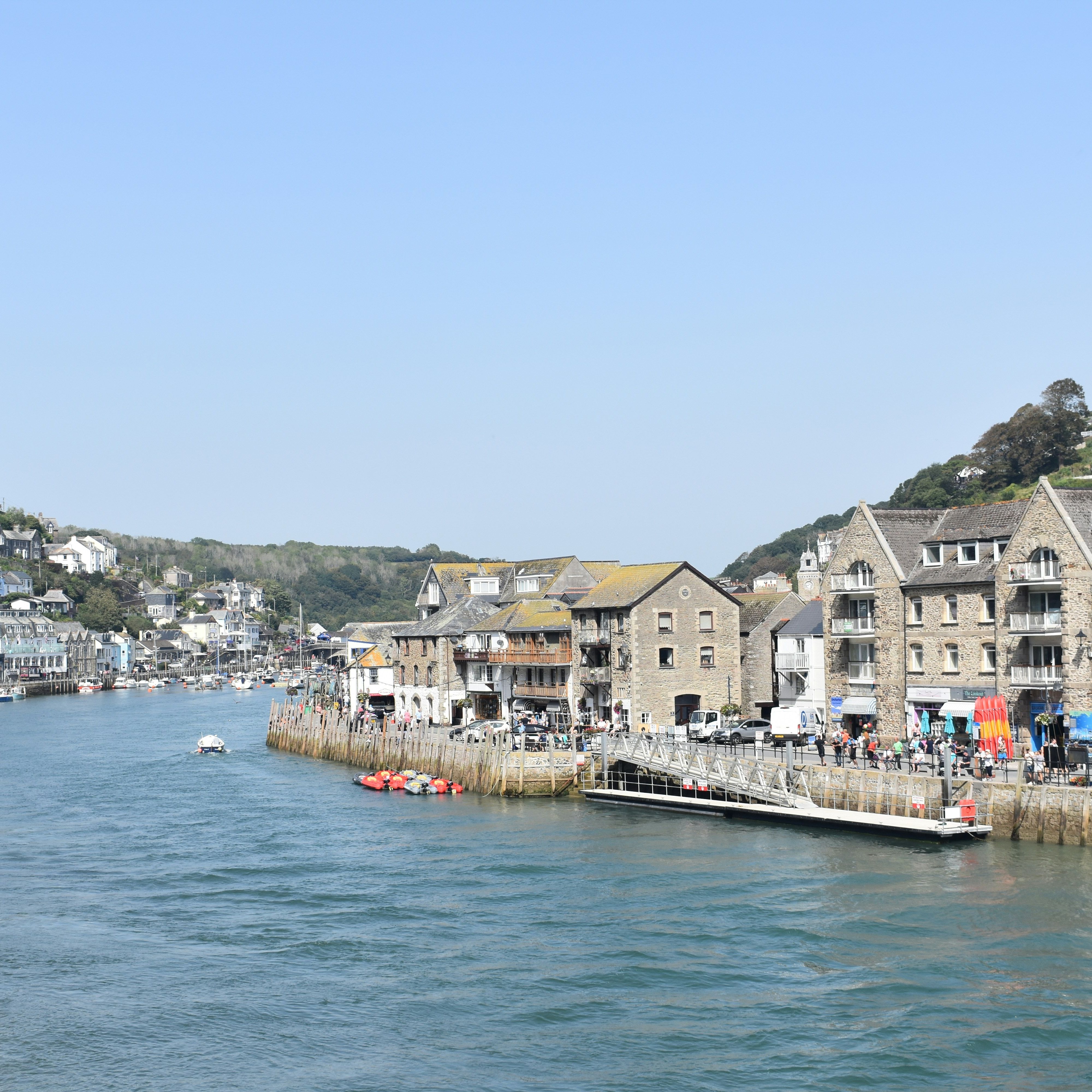 Coastal town with stone buildings and boats along the waterfront on a sunny day