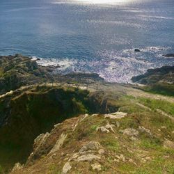 Rocky coastline with shimmering ocean and dramatic cloudy sky