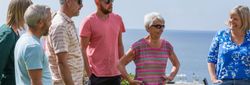 Group of people standing outdoors with the sea in the background