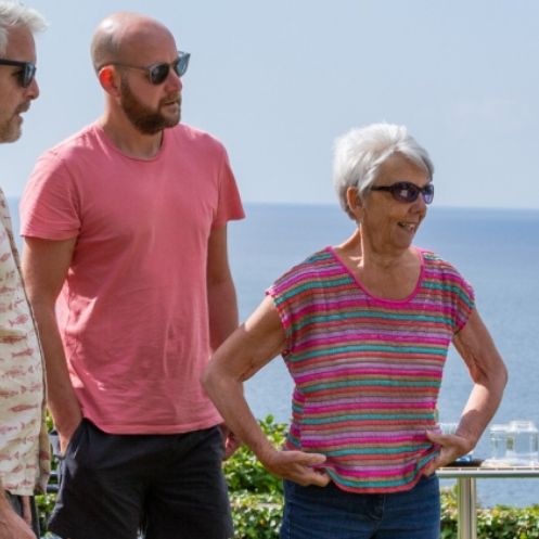 Group of people standing outdoors with the sea in the background