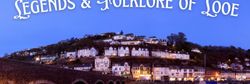 Scenic view of Looe, Cornwall at dusk with illuminated houses, a historic bridge, boats, and the title 'Legends & Folklore of Looe' at the top.
