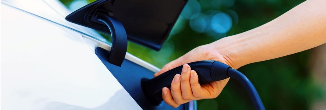 Person plugging a charger into an electric car