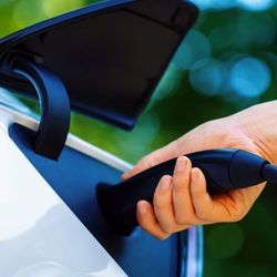 Person plugging a charger into an electric car