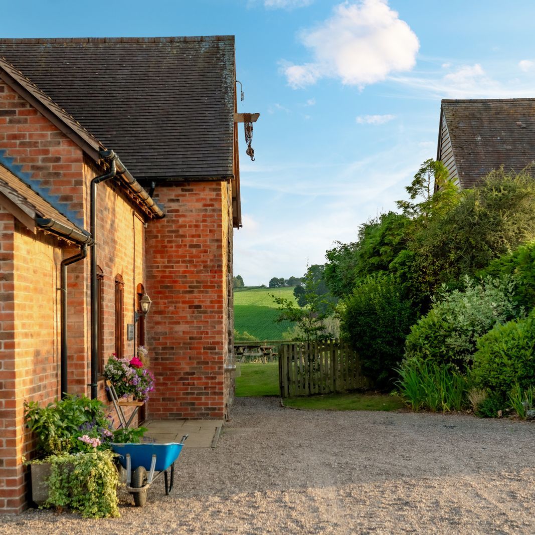 Charming brick country house with lush garden and gravel driveway