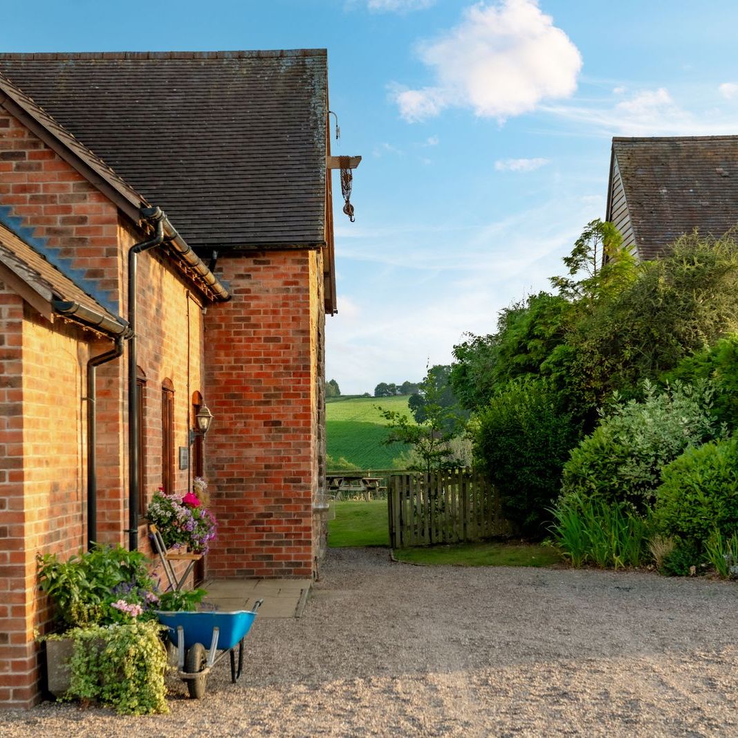 Charming brick country house with lush garden and gravel driveway