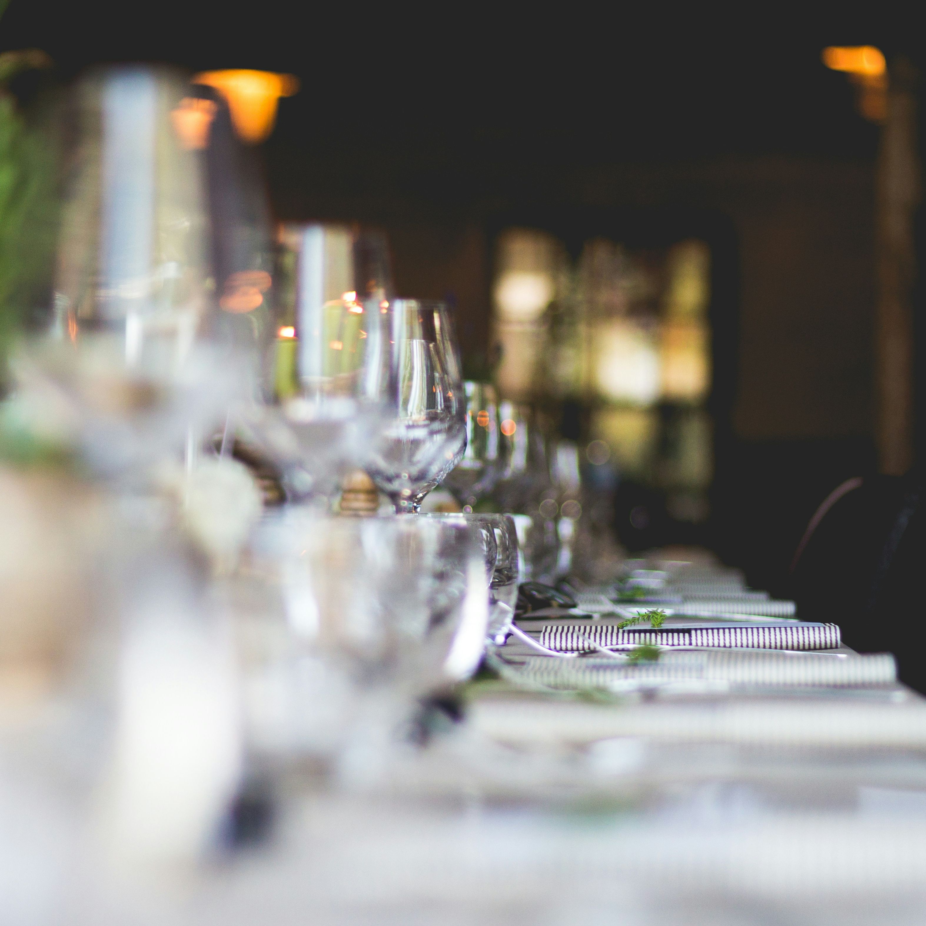 Elegant restaurant table set with glasses, plates, and silverware, prepared for dining.