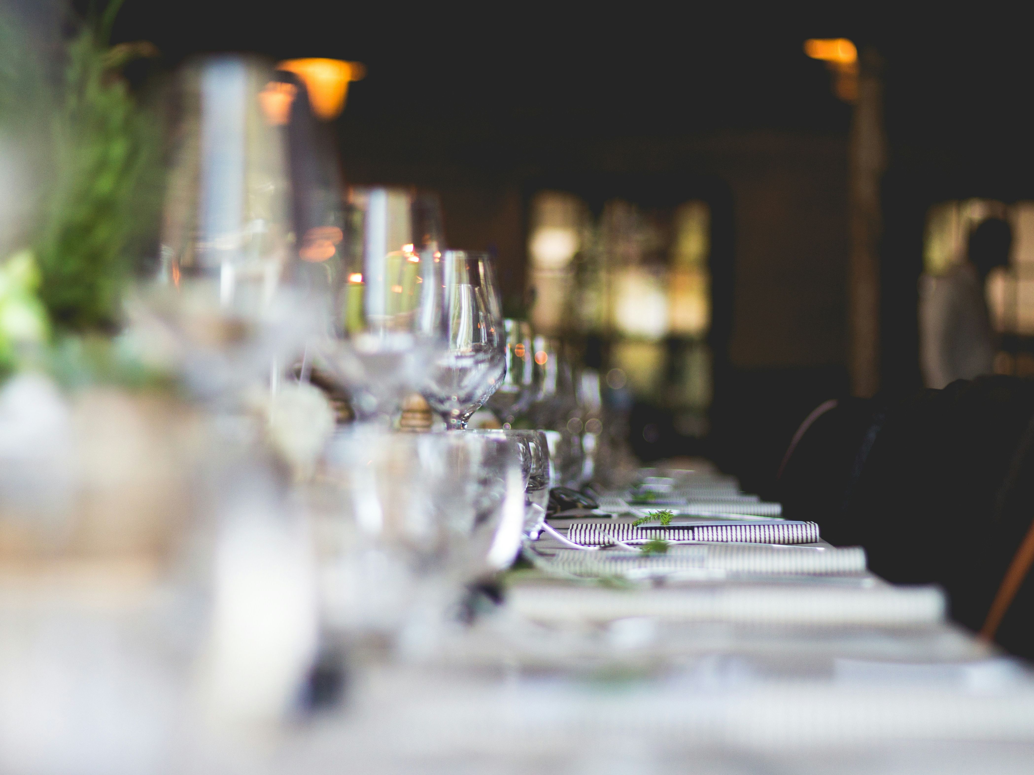 Elegant restaurant table set with glasses, plates, and silverware, prepared for dining.