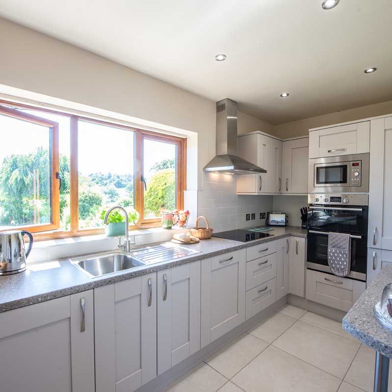 Modern kitchen with light gray cabinets and large window