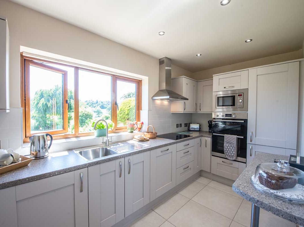 Modern kitchen with light gray cabinets and large window