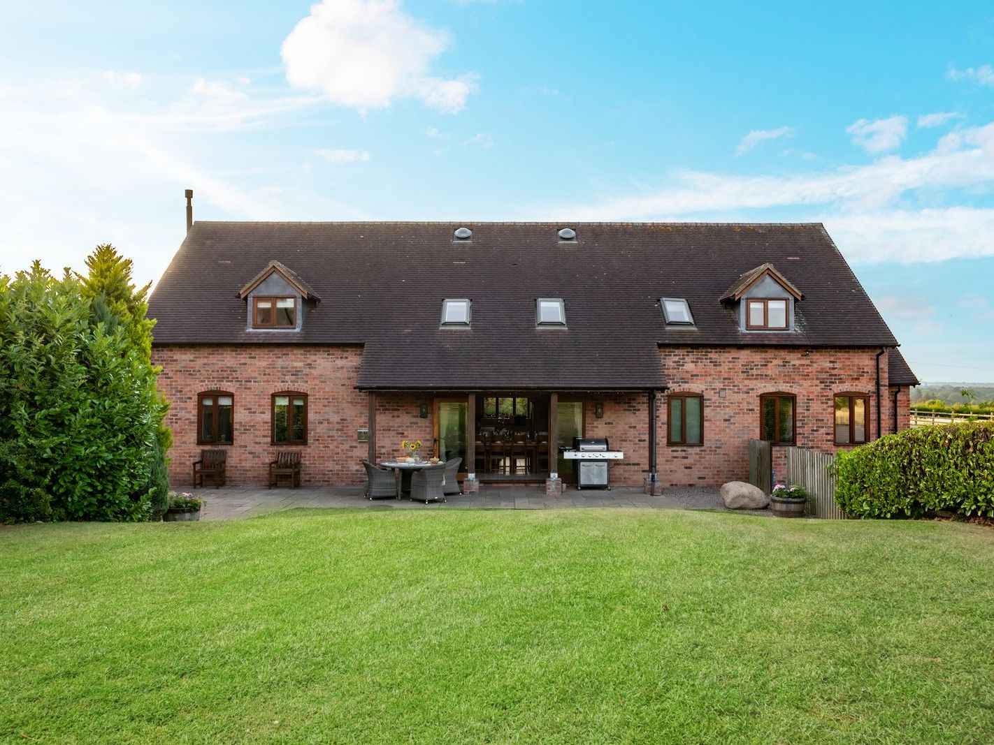 Brick house with gabled roof and large garden lawn