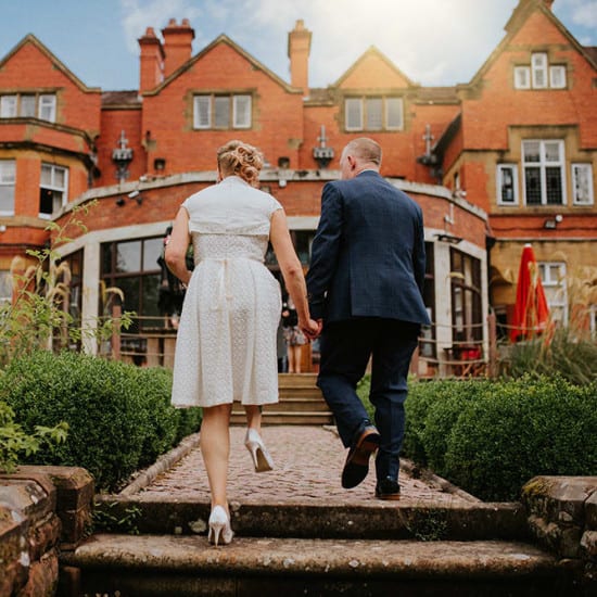 Bride and groom on steps in garden