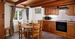 Cozy kitchen with wooden cabinets, dining table, and checkered curtains