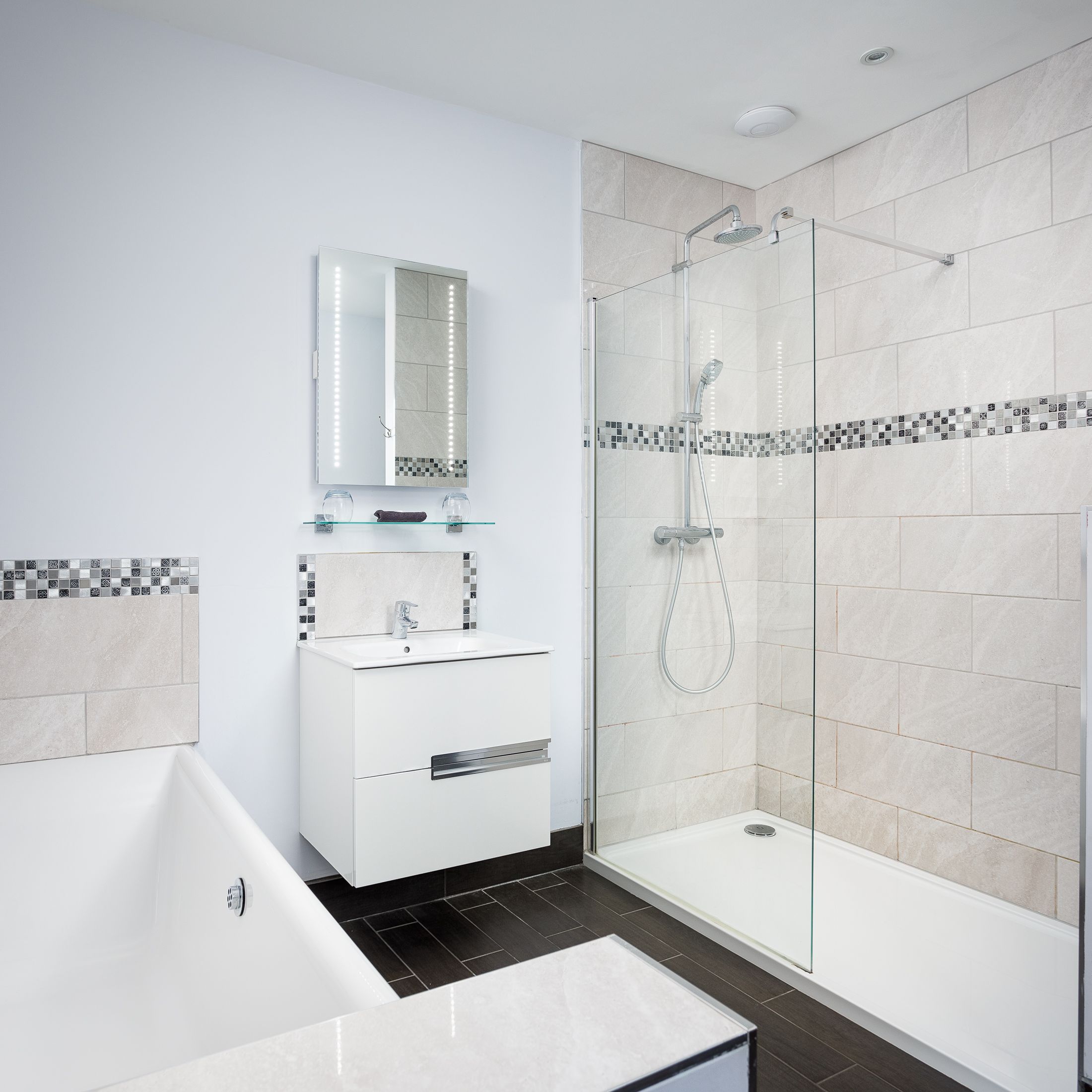 Modern bathroom with a bathtub, walk-in shower, vanity unit and light tiles