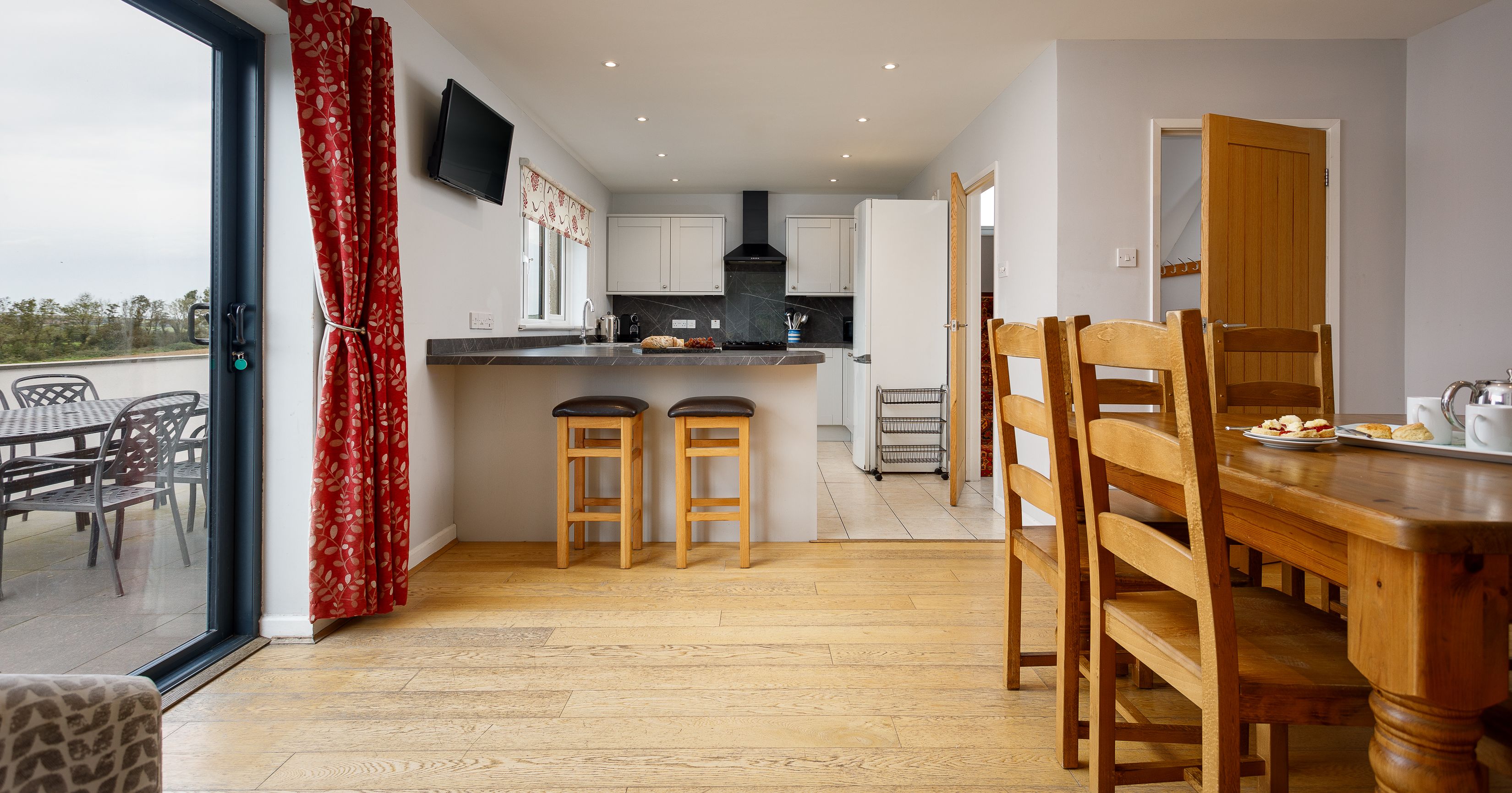 Modern kitchen and dining area with wooden furniture and patio doors