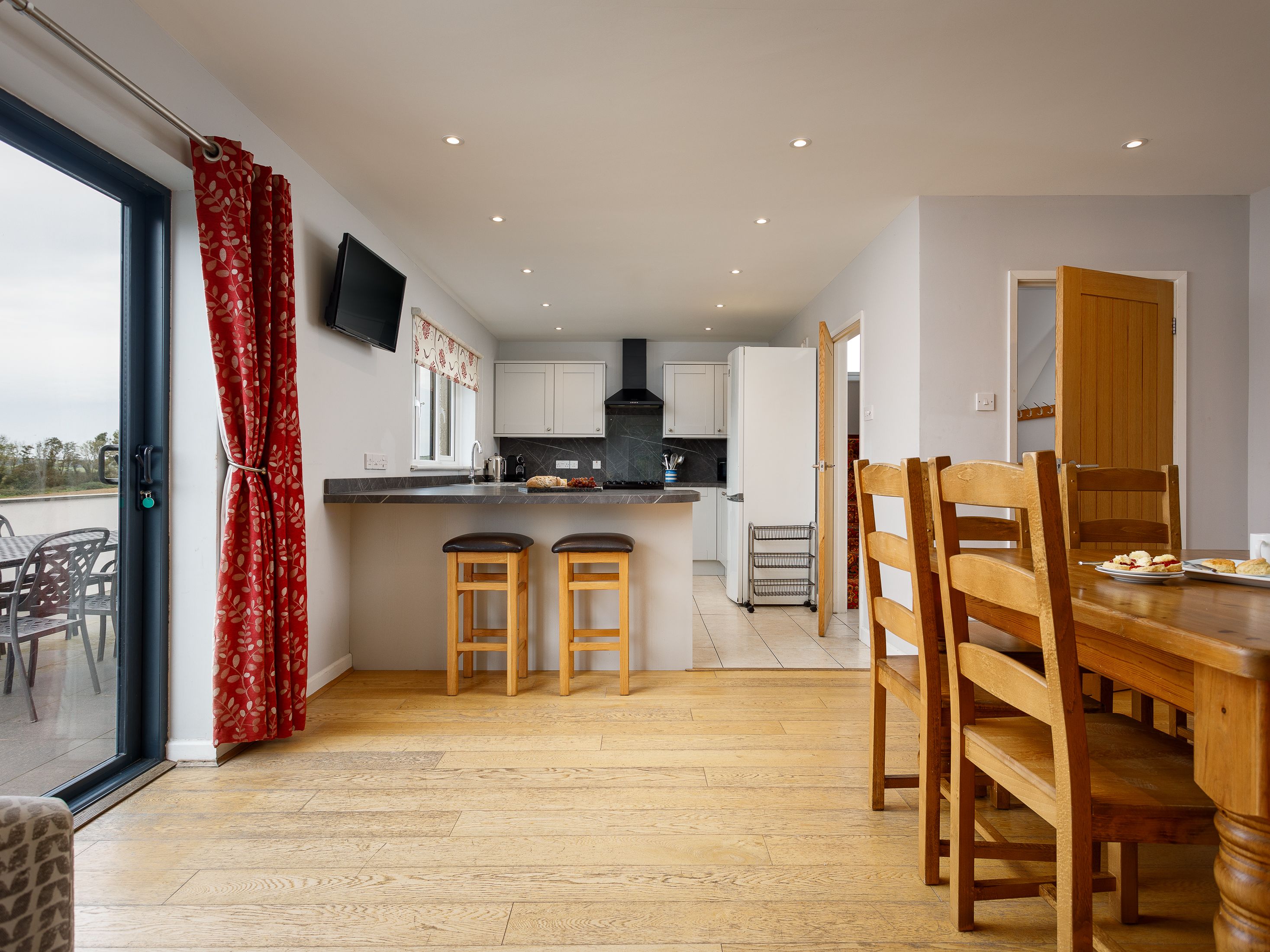 Modern kitchen and dining area with wooden furniture and patio doors
