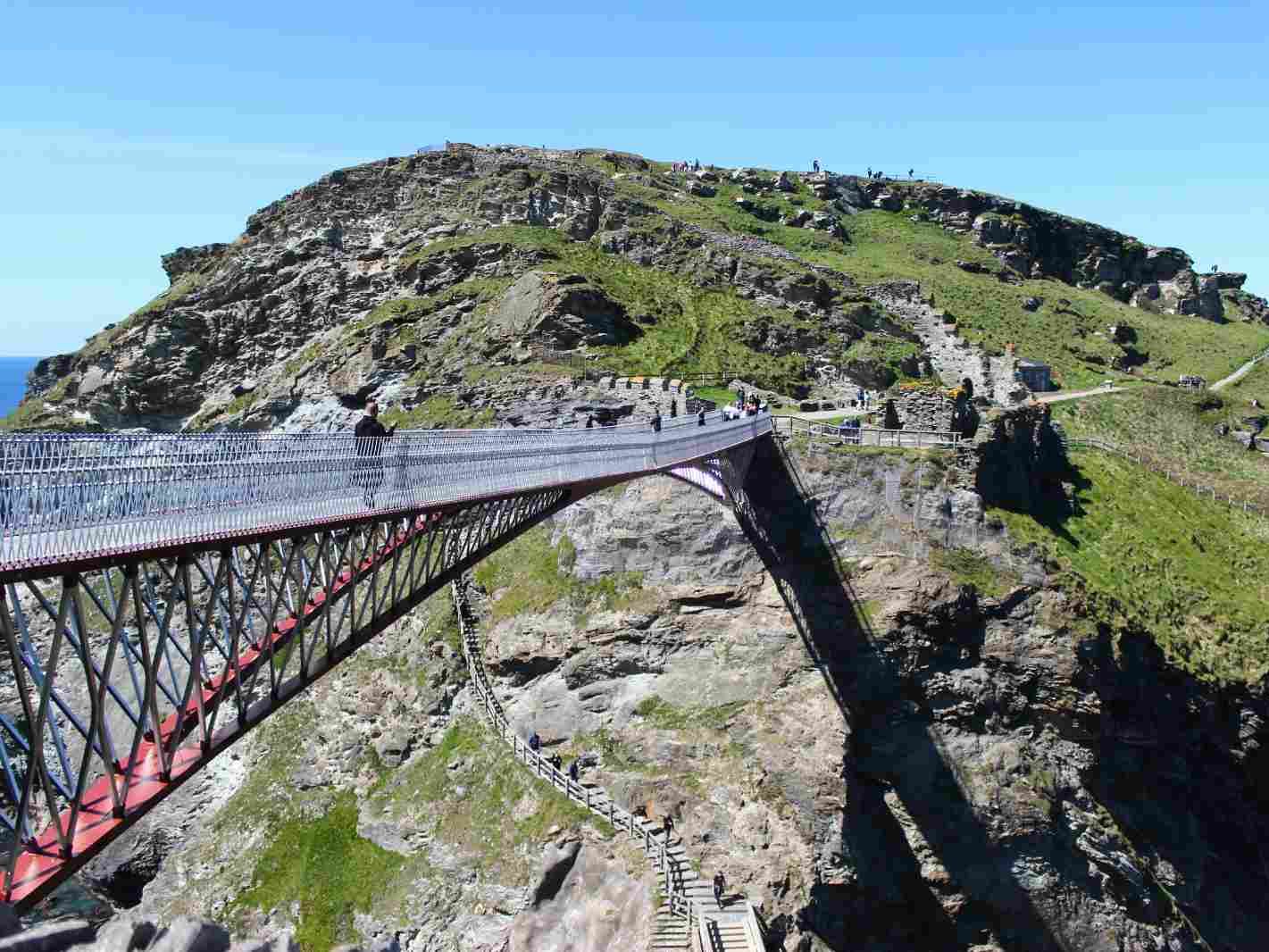 Tintagel Castle footbridge spanning a rocky gorge with people walking across