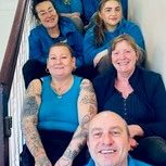 Group of people sitting on a staircase, posing for a photo.