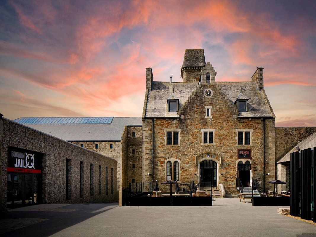 Historic stone building of Bodmin Jail with dramatic sunset sky