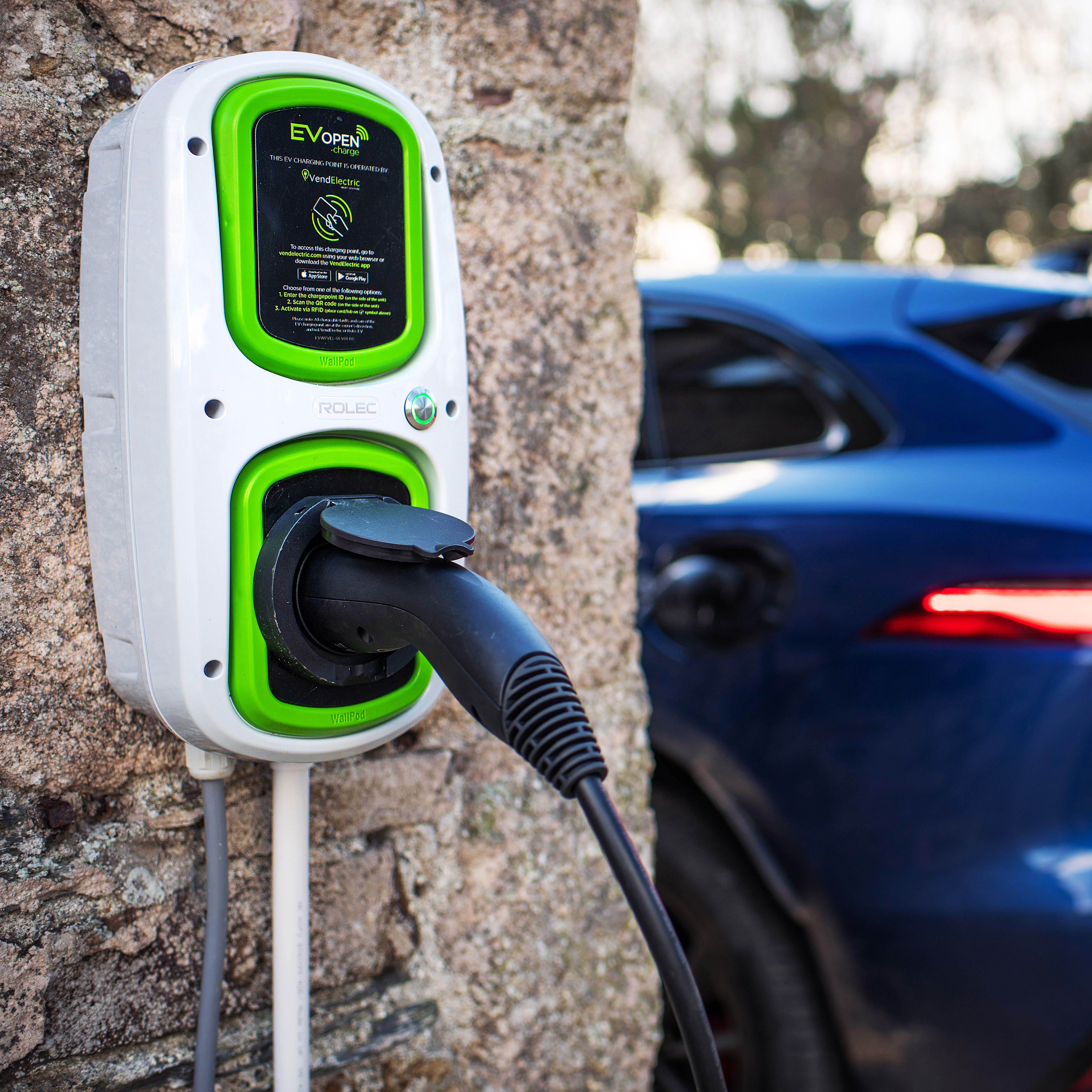 Electric car charging at a wall-mounted EV charger