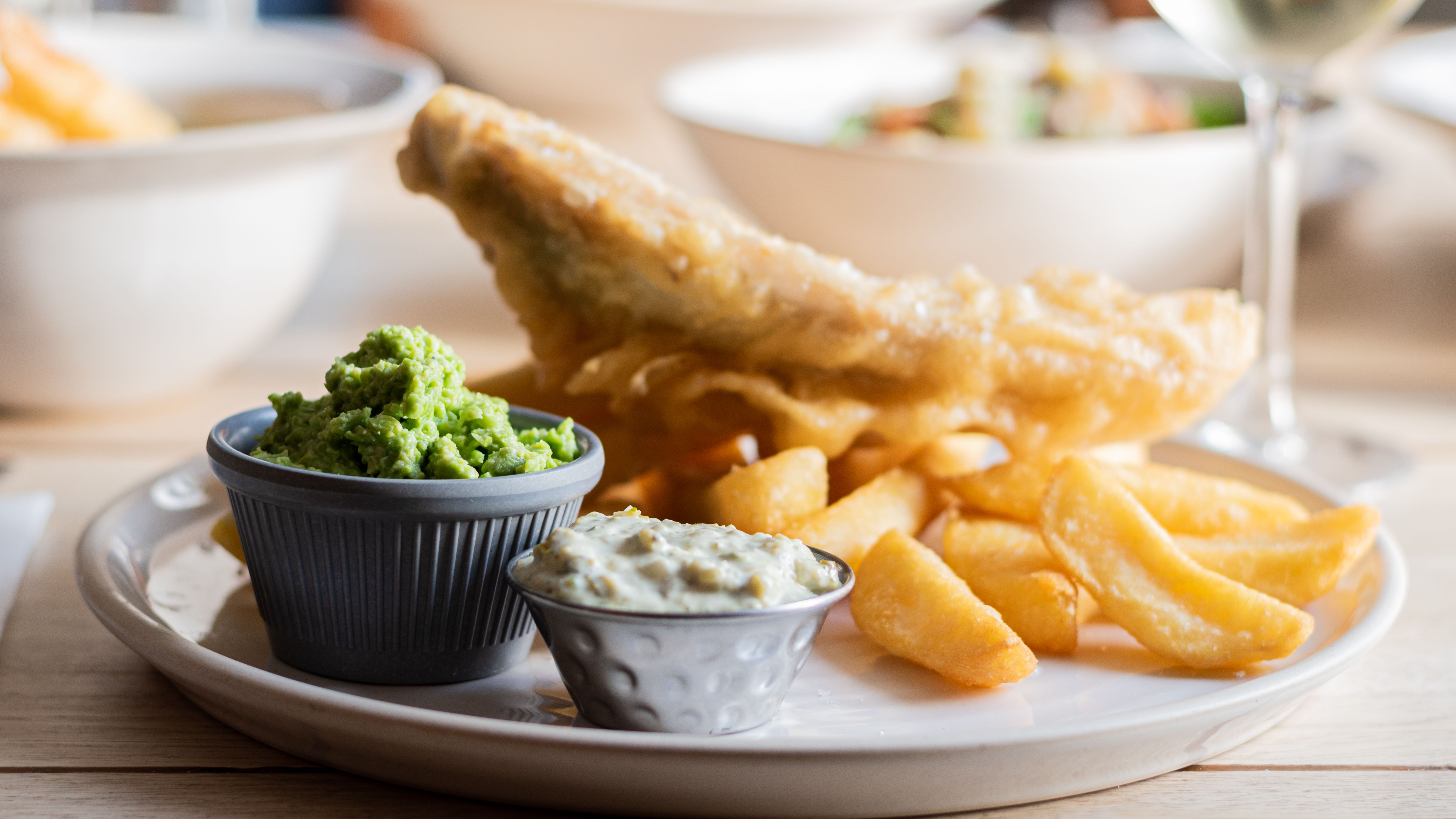 Plate of fish and chips with mushy peas and tartar sauce