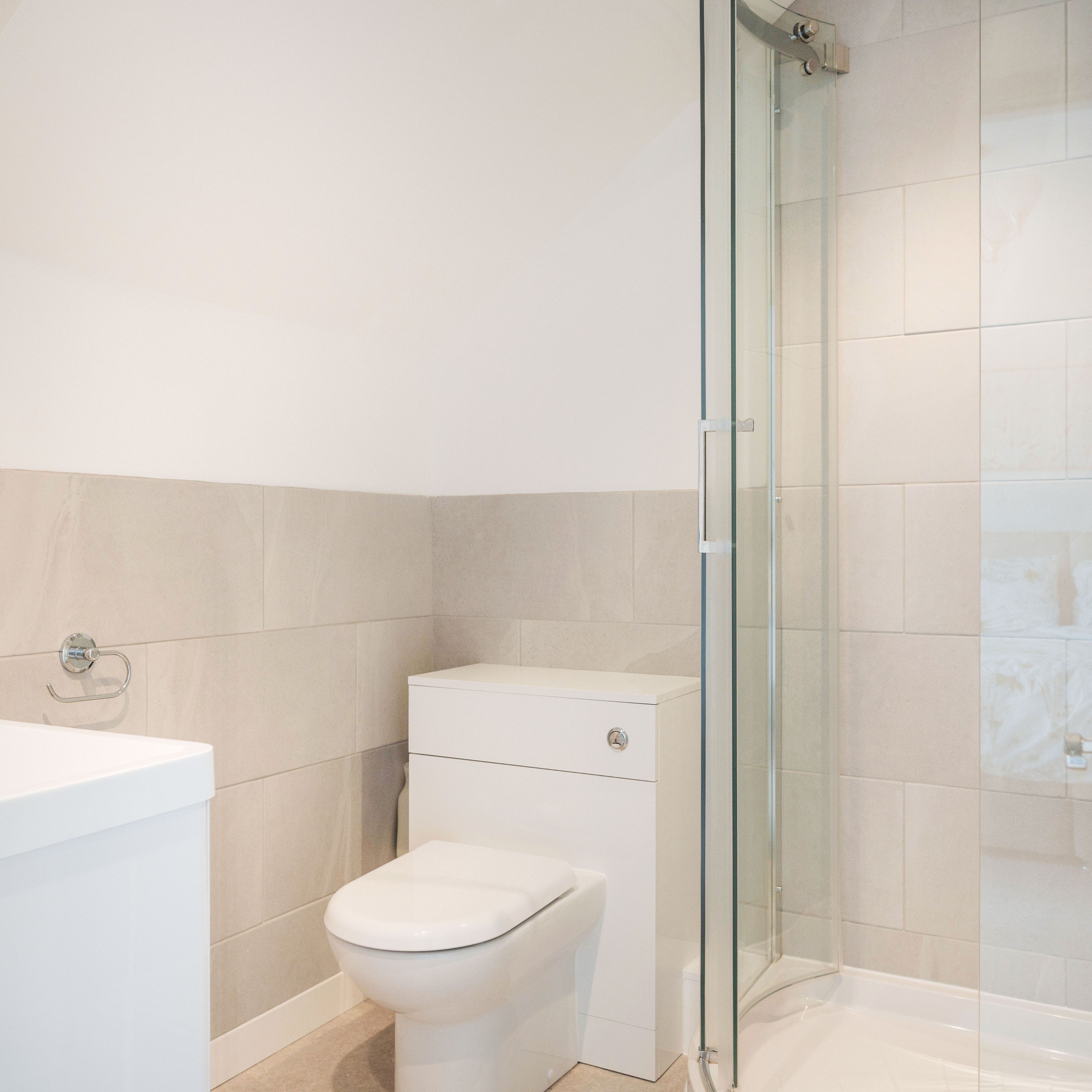 Modern ensuite bathroom with a glass shower, toilet, and sink