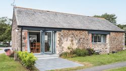 Renovated stone stable with large patio doors and a small garden