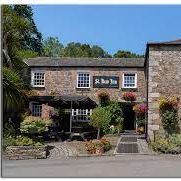 A traditional stone-built inn with flower baskets hanging outside