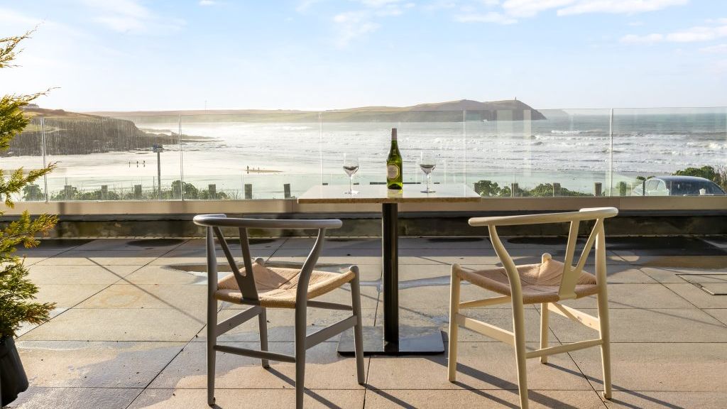 Terrace with two chairs and a table overlooking a scenic ocean view