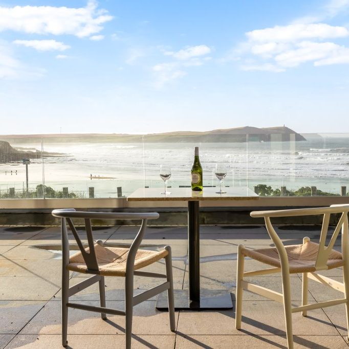 Terrace with two chairs and a table overlooking a scenic ocean view