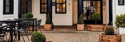 Entrance to The Lion hotel with outdoor seating and black columns