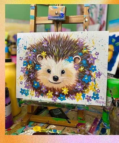 Colorful painting of a hedgehog surrounded by blue, yellow, and purple flowers on an easel.