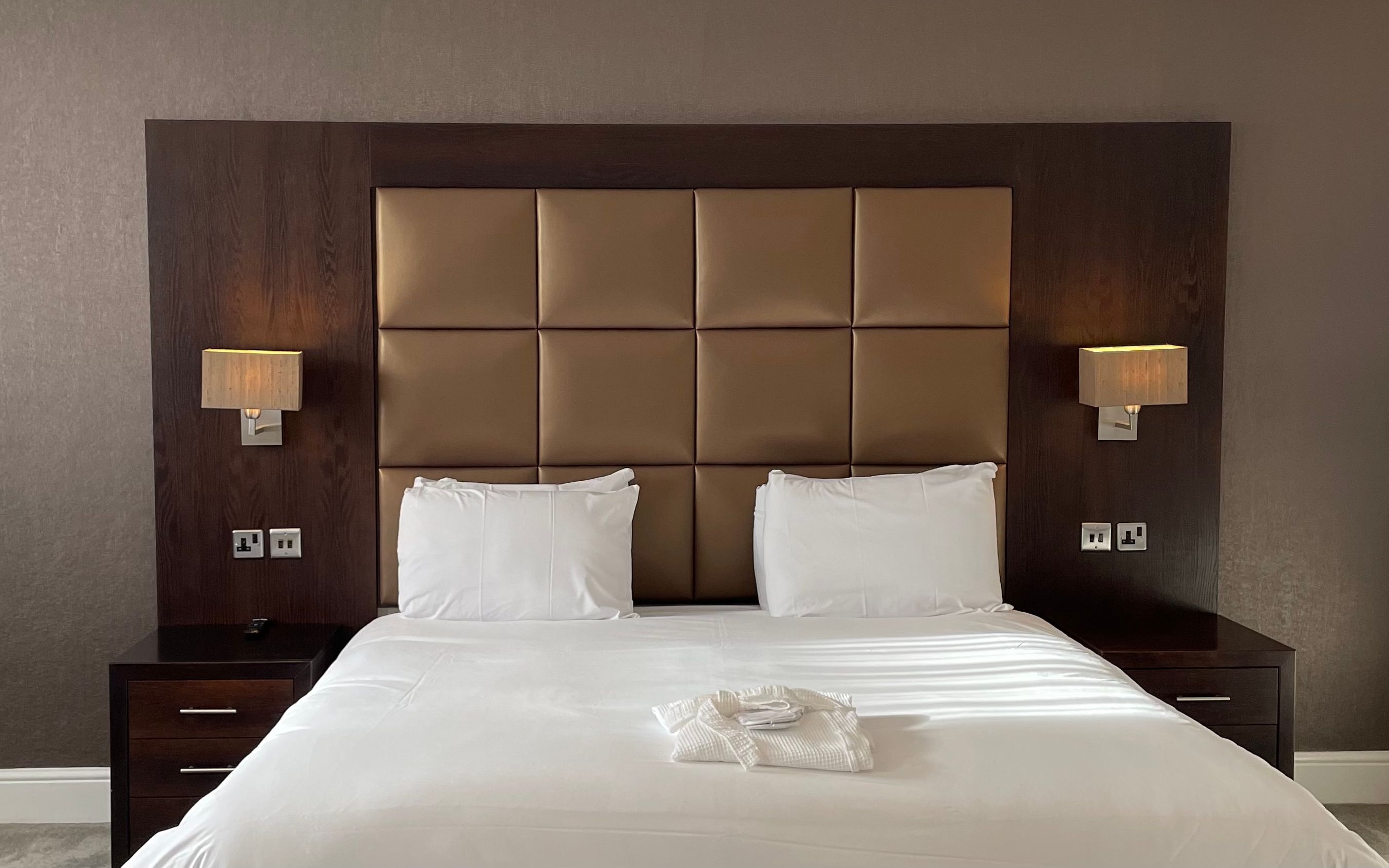 Executive double hotel room with large bed, padded headboard, bedside tables, and lamps