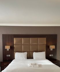 Executive double hotel room with large bed, padded headboard, bedside tables, and lamps