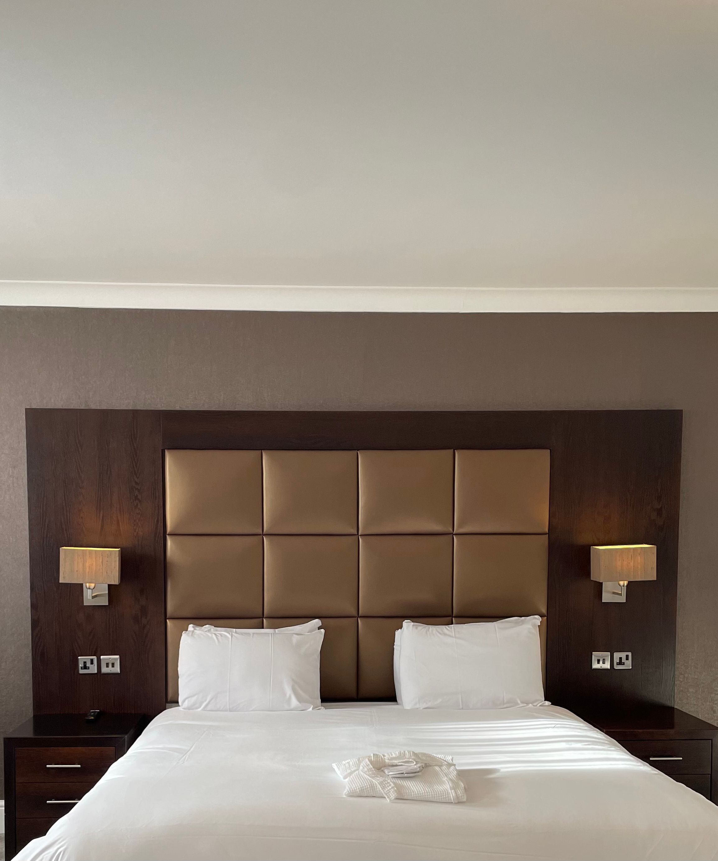 Executive double hotel room with large bed, padded headboard, bedside tables, and lamps