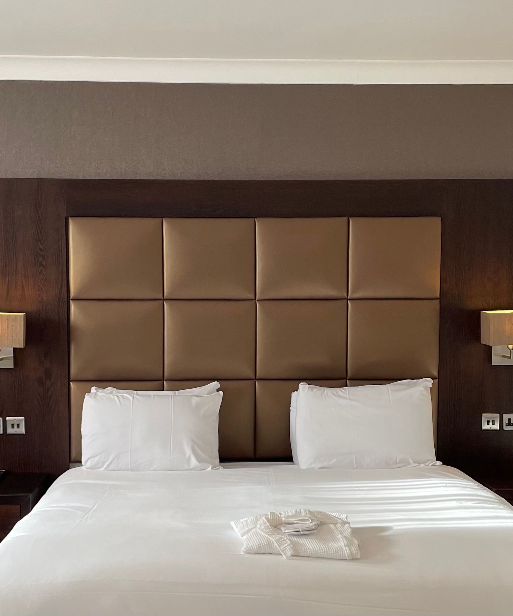Executive double hotel room with large bed, padded headboard, bedside tables, and lamps